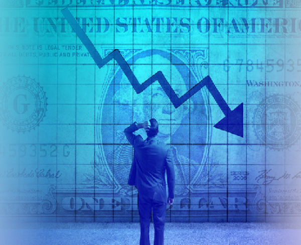 A man standing in front of a projection of a dollar bill with an arrow that is showing the economy is down.